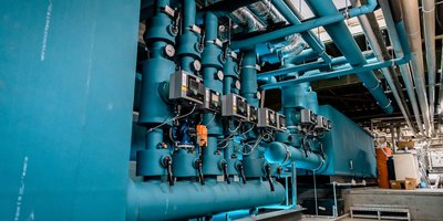 Eine komplexe Anordnung von blauen Rohren und Ventilen, die in einer industriellen Umgebung installiert sind.